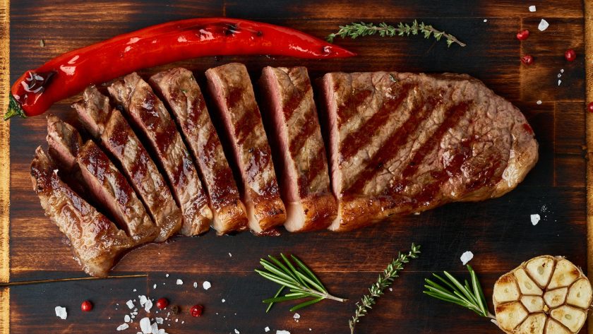 Keto ketogenic diet medium beef steak, grilled striploin on cutting board. Paleo food